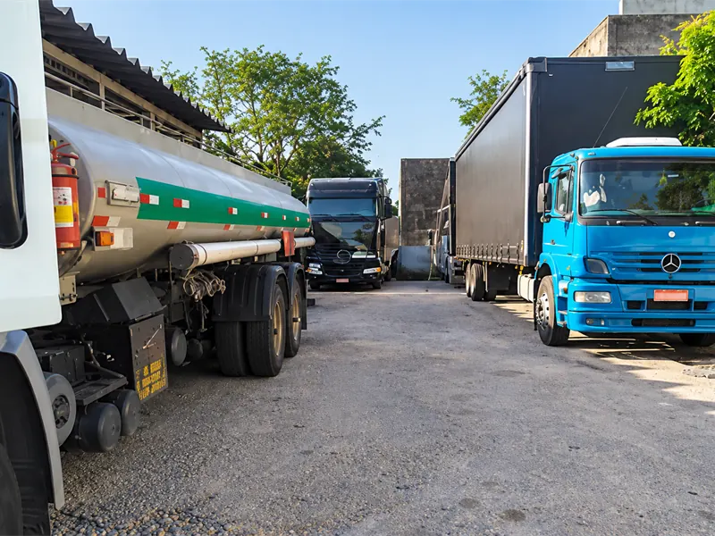 Caminhões de diferentes modelos estacionados lado a lado em um pátio